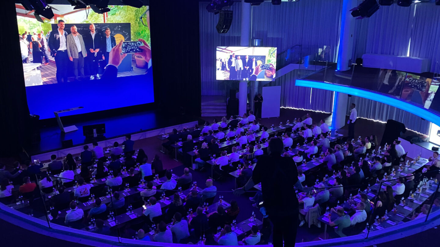 Kongresshalle mit Publikum und Leinwand