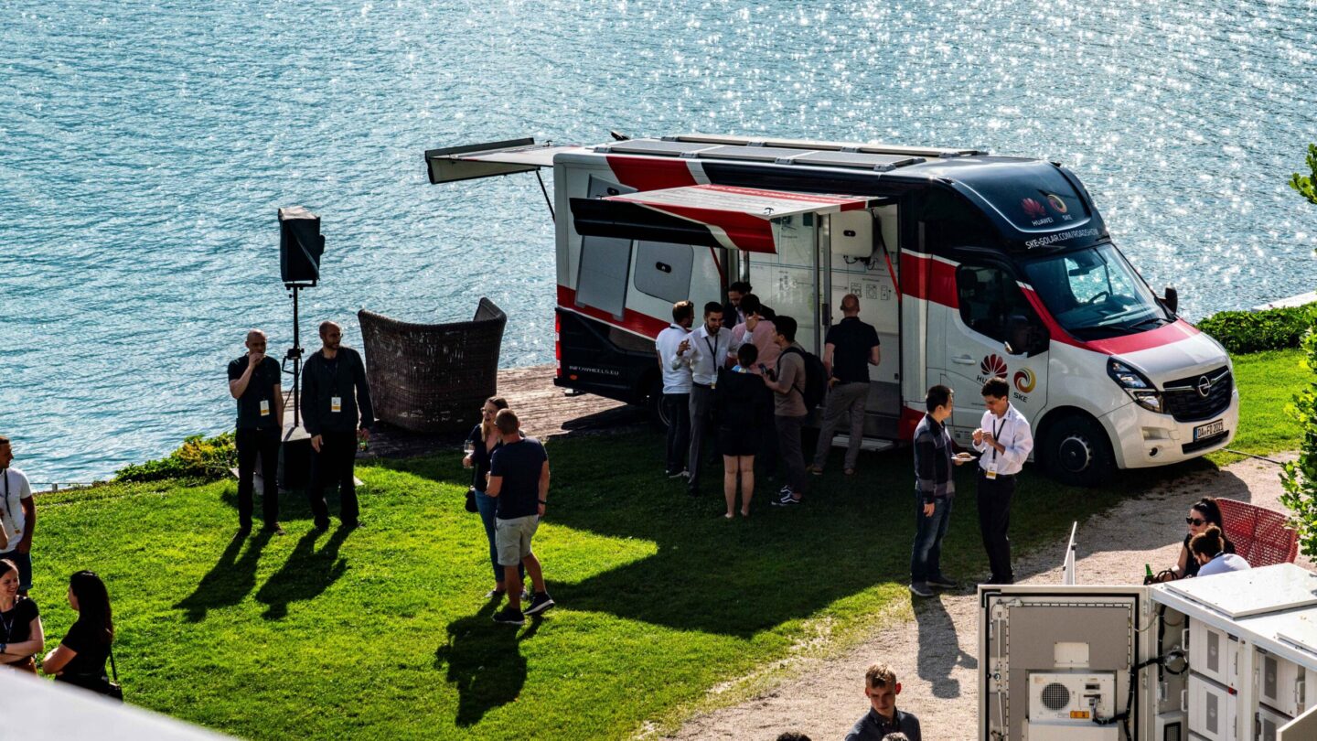 Ausstellungsfahrzeug steht am Ufer eines Sees – Roadshow